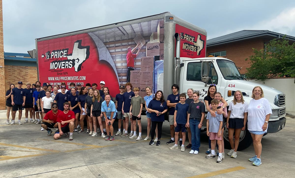 The Half Price Movers family and crew posed in front of a branded moving truck